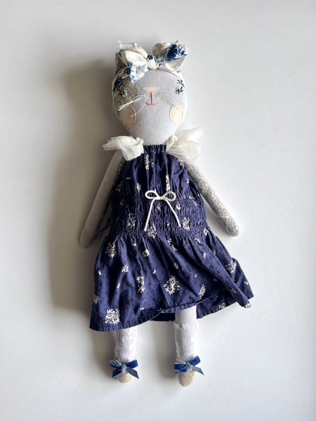 Bespoke cat  doll in a navy dress with white floral patterns on a light gray background