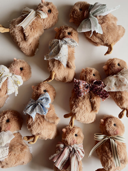 faux fur chick dolls with scarf on a light background