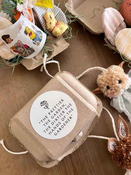 Small brown  egg carton with a white label on a wooden surface with decorative items.