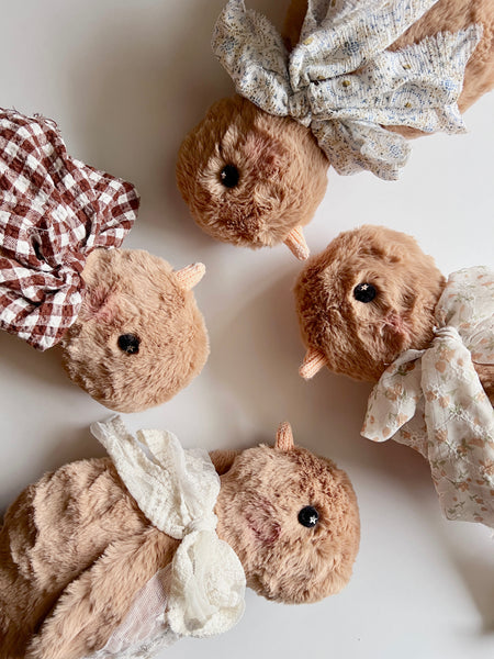 faux fur chick dolls with a white scarves on a light background