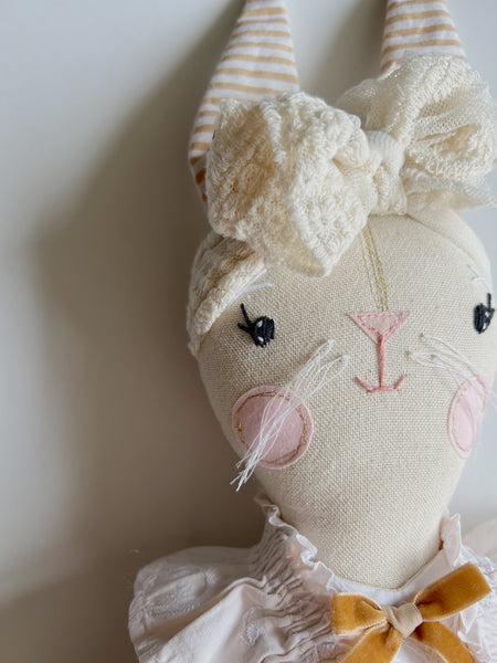 bespoke bunny doll with a white dress on a light gray background