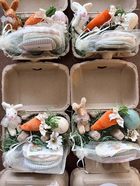 Easter-themed decorations in small cardboard boxes with bunnies, carrots, and eggs.