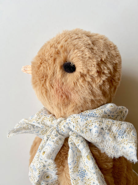 faux fur chick doll with scarf on a light background 