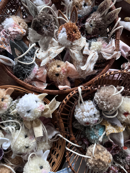 Decorative pom pom animals in woven baskets.