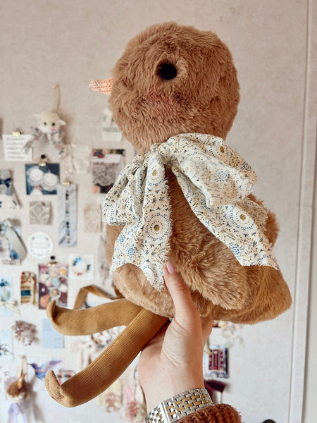 faux fur chick doll with scarf in front on inspo board