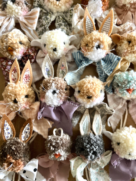 Collection of decorative bunny figurines with various textures and colors on a textured background.
