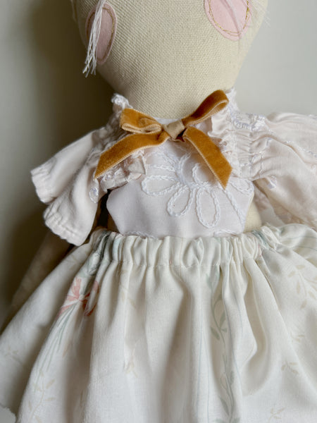 bespoke bunny doll  up close with a white dress on a light gray background